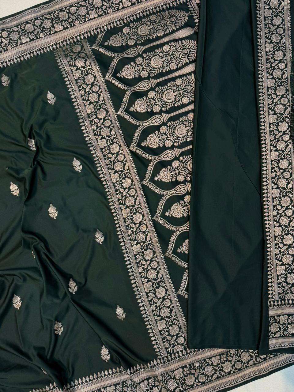 Dark green Mashru silk saree by Kalisa Banaras with intricate traditional patterns and a smooth, lustrous fabric.
